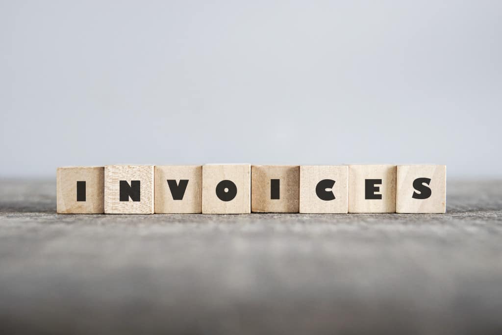 wooden blocks with the letters spelling invoices