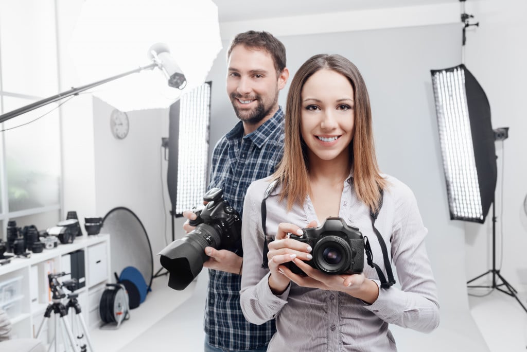 man and woman in s studio holding a camera