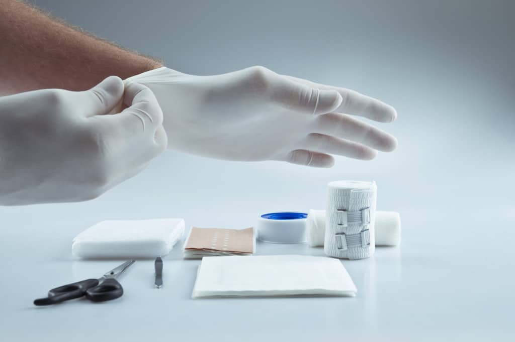 a hand reaching out for wound supplies